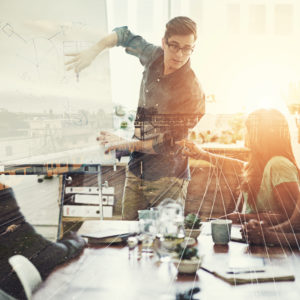 Multiple exposure shot of a business group superimposed over a train track